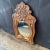 A French carved wood mirror from the 19th century. This antique mirror from France is set within a rectangular-shaped...