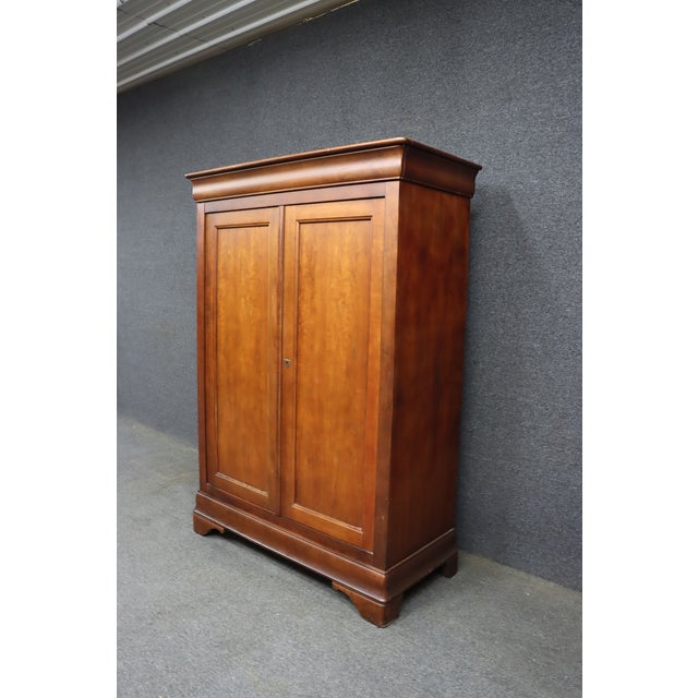 Classic Louis Philippe style armoire attributed to National Mount Airy, crafted in warm cherry with clean paneled doors, a...
