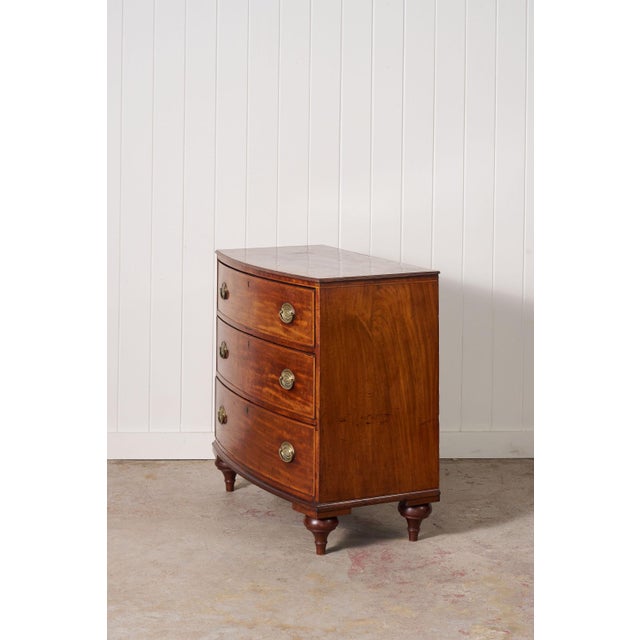 Early 19th century mahogany bowfront chest featuring elegant inlaid detailing, rich mahogany grain, and beautifully aged...