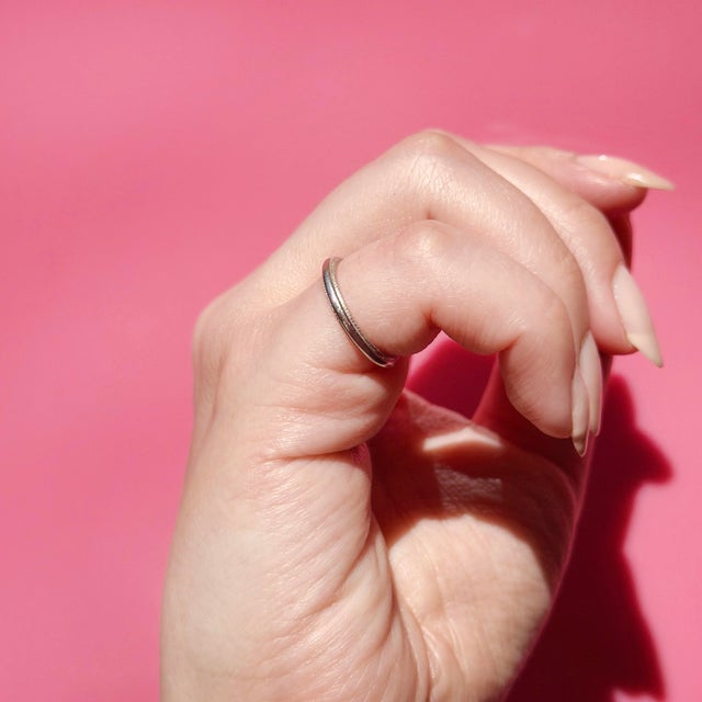 About This Ring: A timeless platinum wedding band carrying the beautiful inscription "D.E.N. & A.N.L. 5-17-69," a precious...