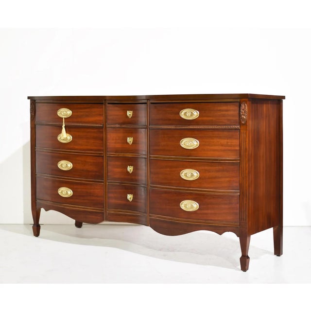 Elegant curves and timeless proportions define this mid century Federal-style triple dresser by Dixie. Crafted in rich...