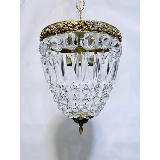This is adorable vintage brass frame basket chandelier with graduated crystal chain. It has two Edison based sockets that...