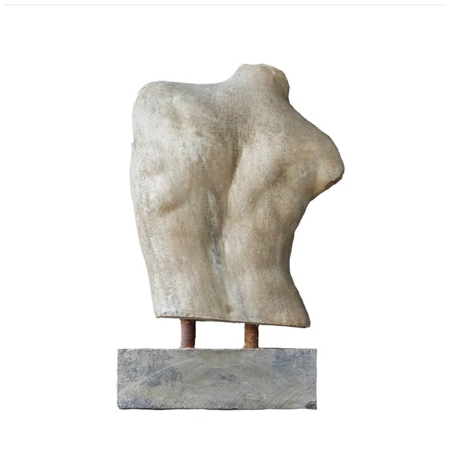 A beautifully weathered classical torso sculpture inspired by ancient European fragments and museum artifacts. Resting on...