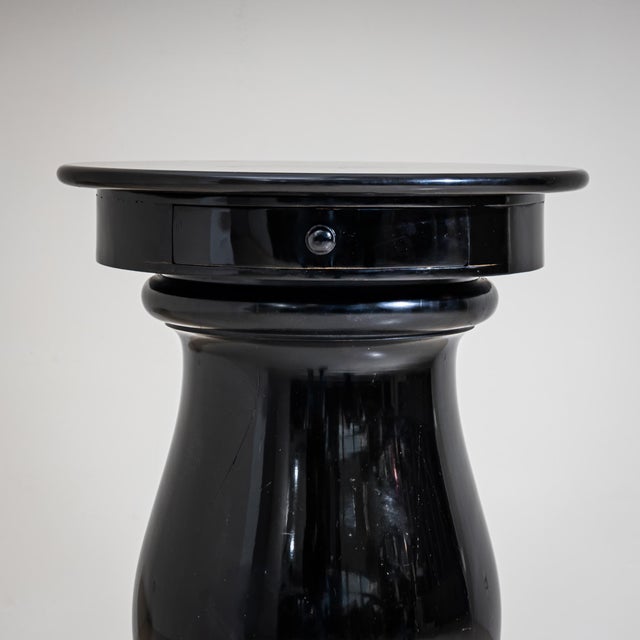 Pair of vase-shaped side tables with black marble tops, each fitted with a single drawer and an ebonized body. Suitable...