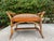 A charming vintage woven rattan and bamboo ottoman stool featuring a sculptural British Colonial-inspired silhouette with...
