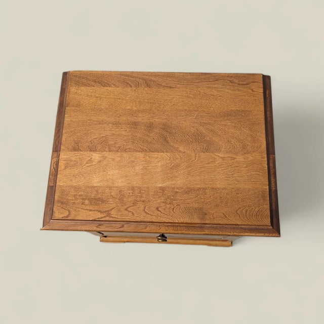 A handsome pair of vintage nightstands by L.A. Period Furniture, each with a warm wood finish, two drawers, an open lower...