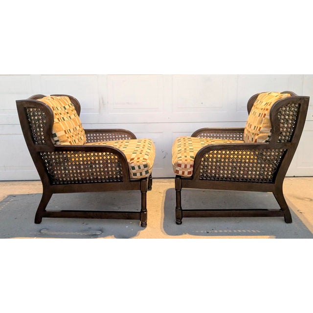 A handsome pair of vintage Henredon low-profile wingback lounge chairs featuring dark-finished oak wood frames, gracefully...
