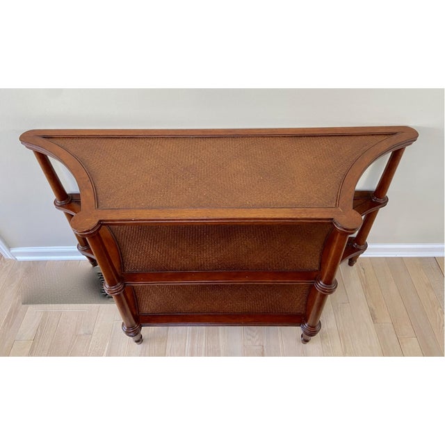 A vintage, shaped entryway or sofa console table by Ethan Allen with three tiers of tightly hand-woven rattan shelves....