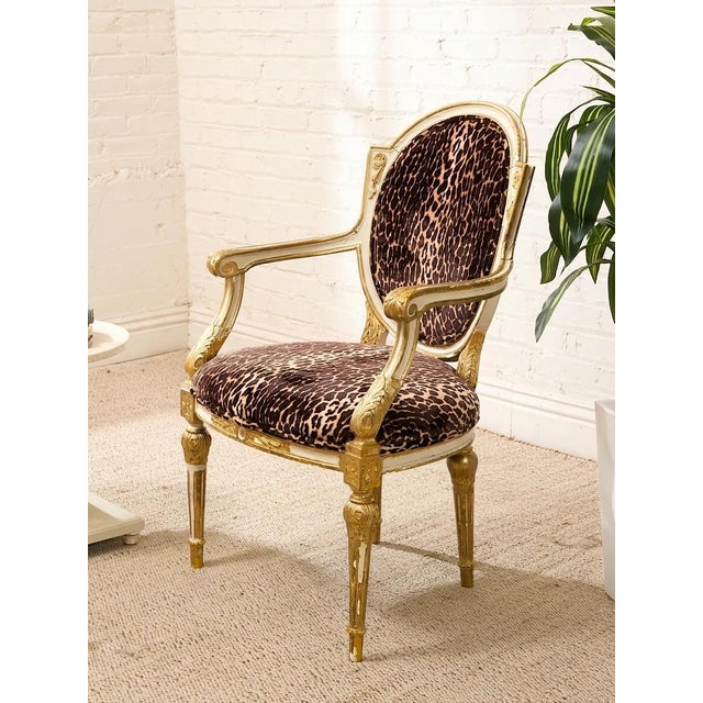 A fabulously dramatic French Louis XVI style armchair pairing an ornate giltwood frame with bold leopard-print upholstery....