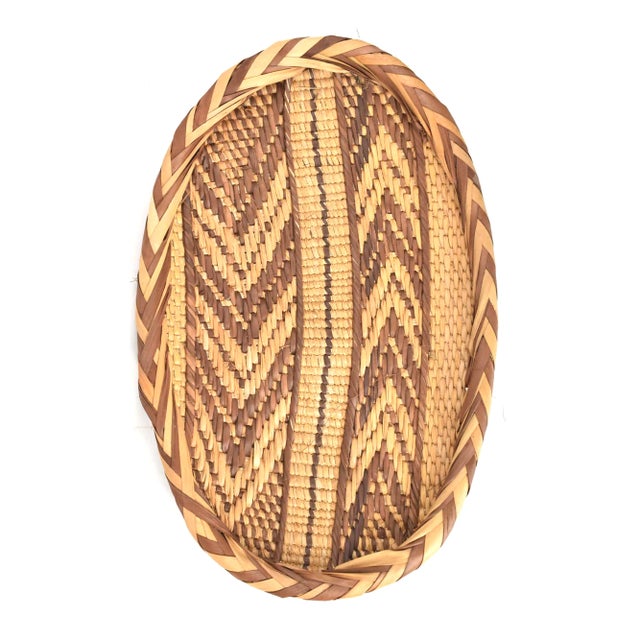 A beautiful, handwoven basket from Zimbabwe's Gokwe region with abstract designs in tan and brown.
