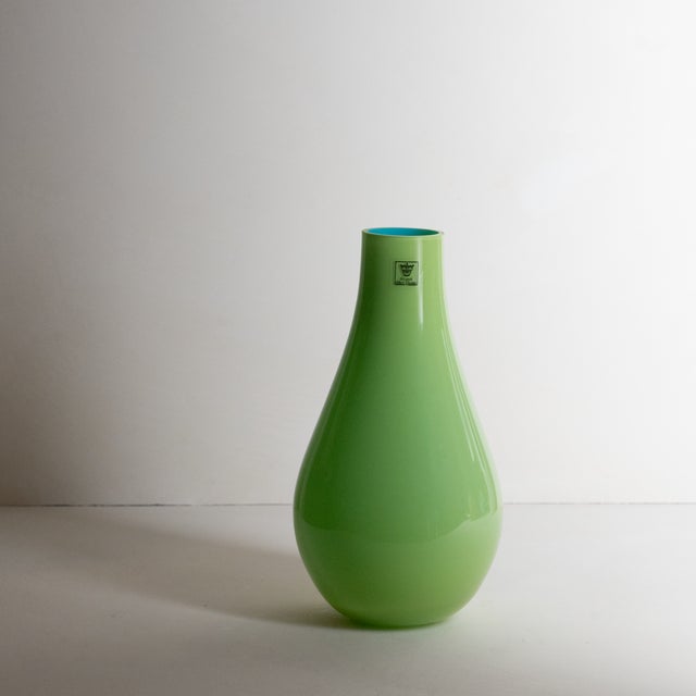 Beautiful, minimalist art glass flower pitcher, featuring a lime green exterior and a turquoise blue interior. Hand blown...