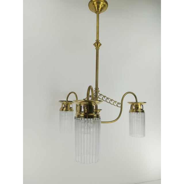 3-arm solid brass French chandelier with glass rods. The lamp has been rewired and reelectrified to today's safety...
