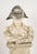 Depicted in his iconic bicorne hat and contemplative crossed-arm pose, Napoleon rests atop an architectural pedestal...