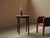 Round side table in solid wood stands on four turned, tapered legs decorated with ring motifs. The circular top, with a...