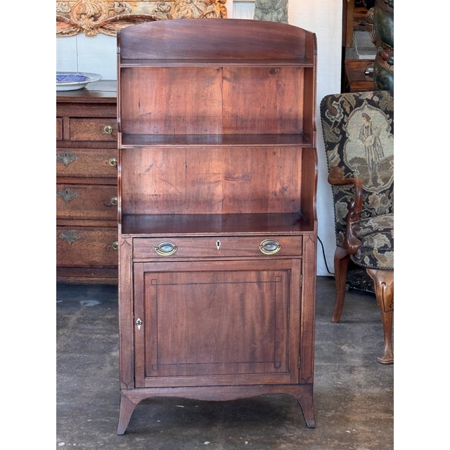 An English mahogany waterfall bookcase — three graduated open shelves stepping back in the classic waterfall shape, over a...