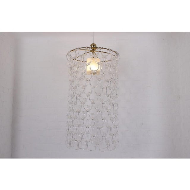 Large pendant light with circular frame in solid brass, composed of 195 mouth-blown elements, each forming a double hook...