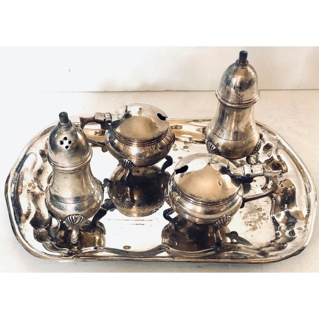 This is a 5 piece set of silver service pieces consisting of a silver plated salt, pepper, two condiments and tray in the...