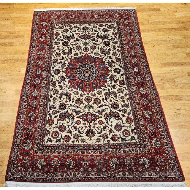 "An elegant and finely woven vintage Persian Isfahan room size rug, hand-knotted in the mid-20th century and showcasing...