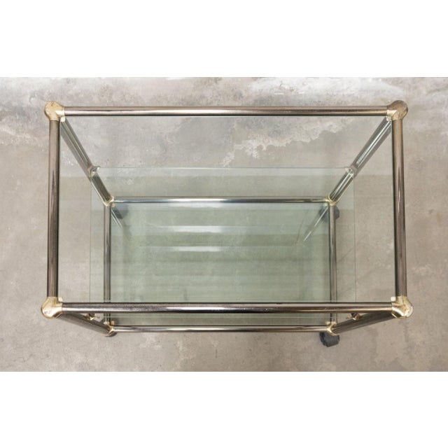 Elegant 1970s Hollywood Regency-style serving cart (or multi-purpose shelf), featuring a refined metal frame with a...