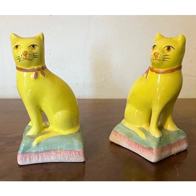 Pair antique 19th century English Staffordshire canary yellow cats wearing pink ribbons. Each measures 4 1/8" tall x 2...