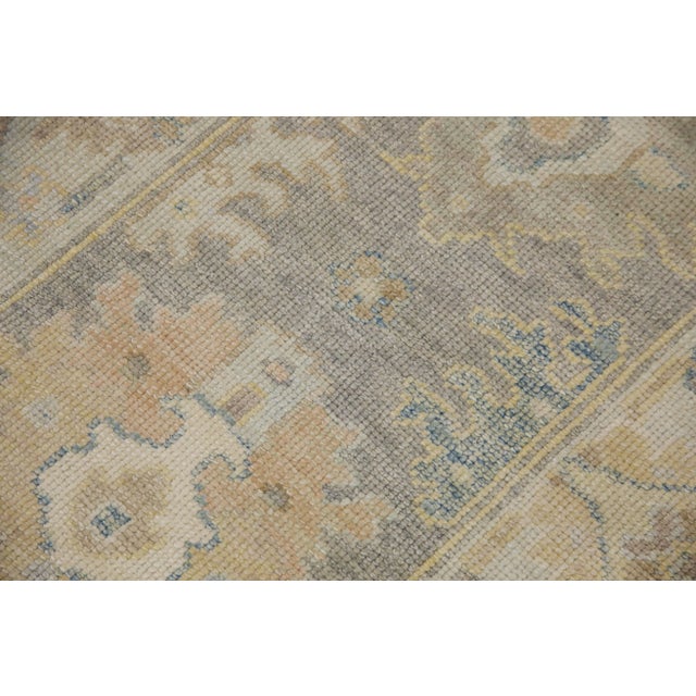 This modern Turkish Oushak rug is a stunning piece of art that has been handwoven using traditional techniques by skilled...