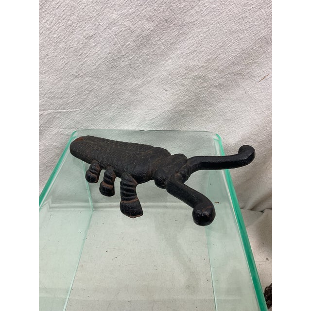 Figural iron beetle bug with spread antenna for grasping heel of boot and removing from foot. C1930s Painted black all...