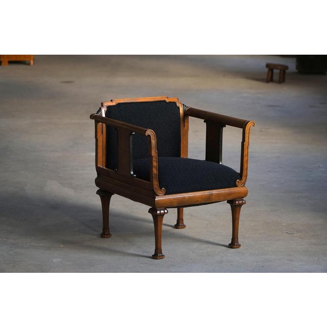 A beautiful Danish Art Nouveau armchair, crafted in stained birch wood and characterized by its strong architectural...