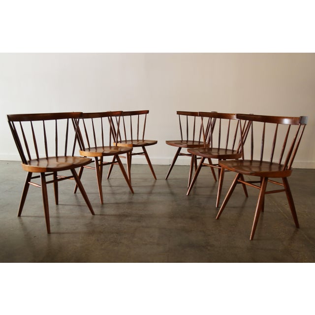 A set of 6 straight back chairs attributed to George Nakashima Studios c. 1960s. Hand carved spindles, sculpted seat,...