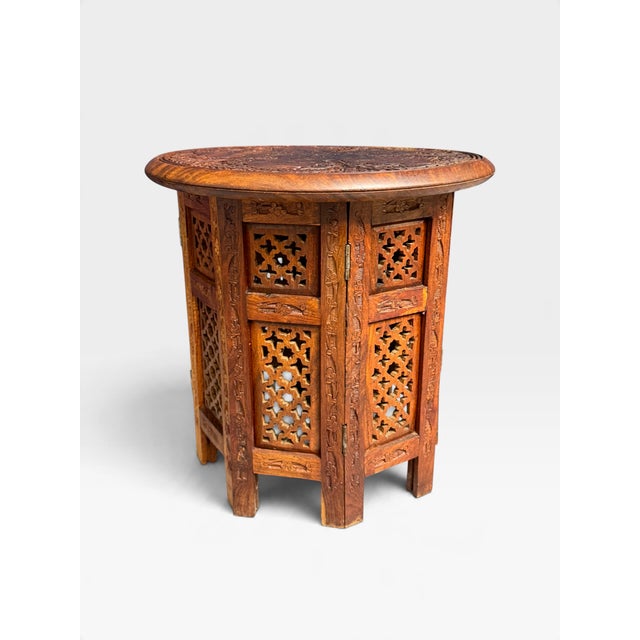 This item is a small hand-carved folding table from Hoshiarpur, India, created around 1950. The table features intricate...