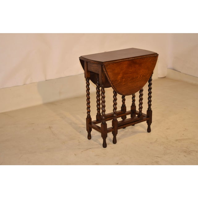 Period Edwardian oak gate-leg table from England, circa 1900. The top has lovely graining and a beveled edge. The top...