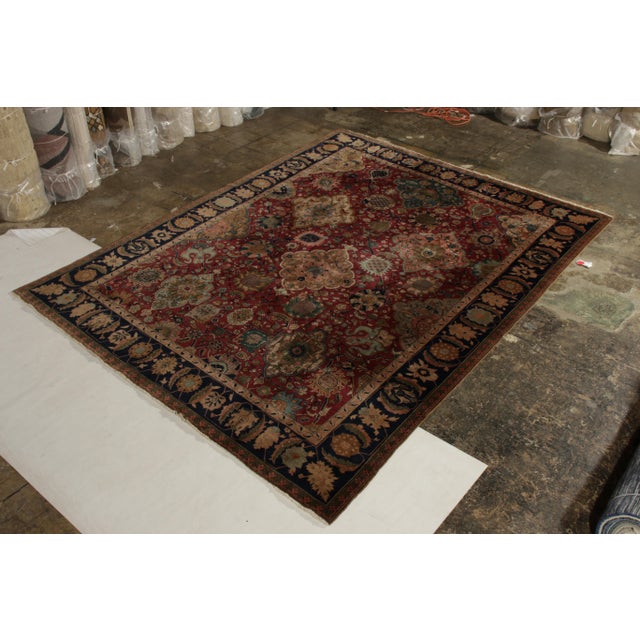Hand knotted in wool originating from Nepal circa 1910-1920, this 9x12 antique rug connotes a Shahrestan rug design of...