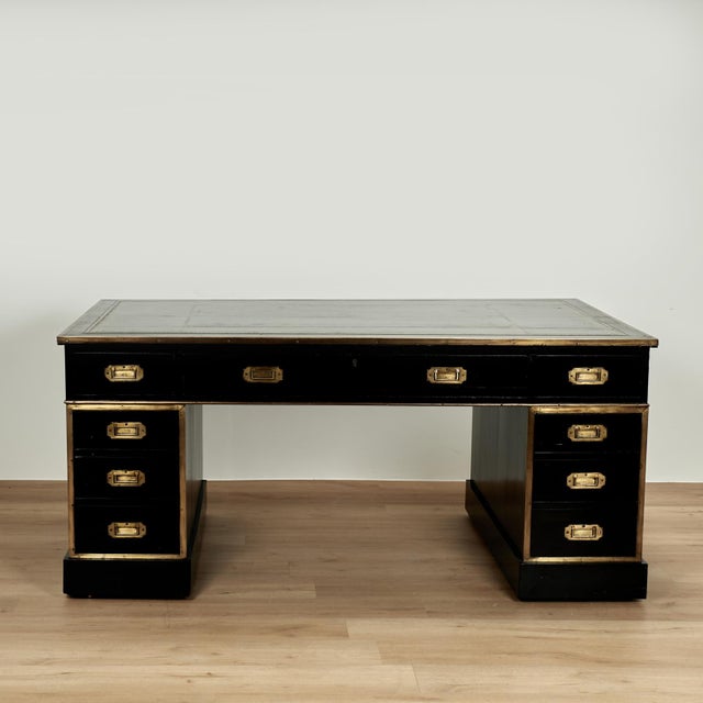 Handsome 19th century English desk handcrafted in mahogany with an ebonized finish, featuring a tooled green leather top...
