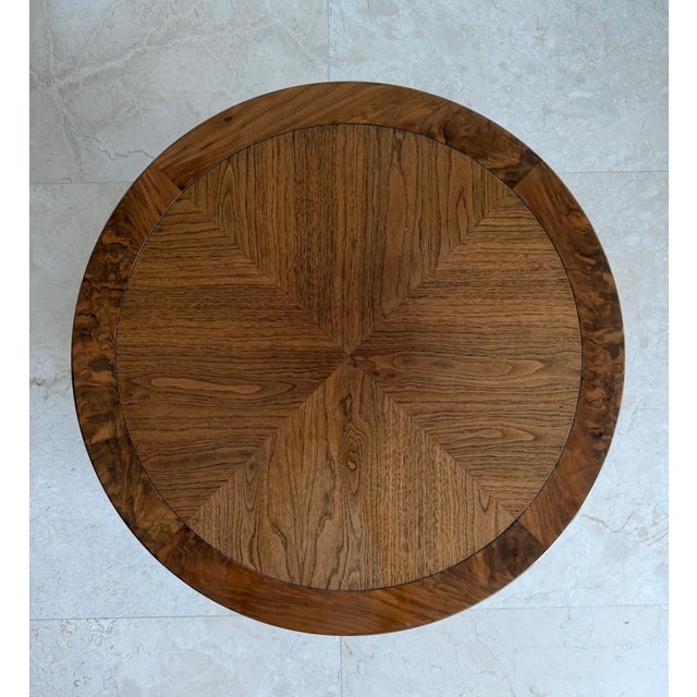 Elegant vintage round drum-form side table featuring a warm brown wood finish and a beautifully patterned veneer top with...
