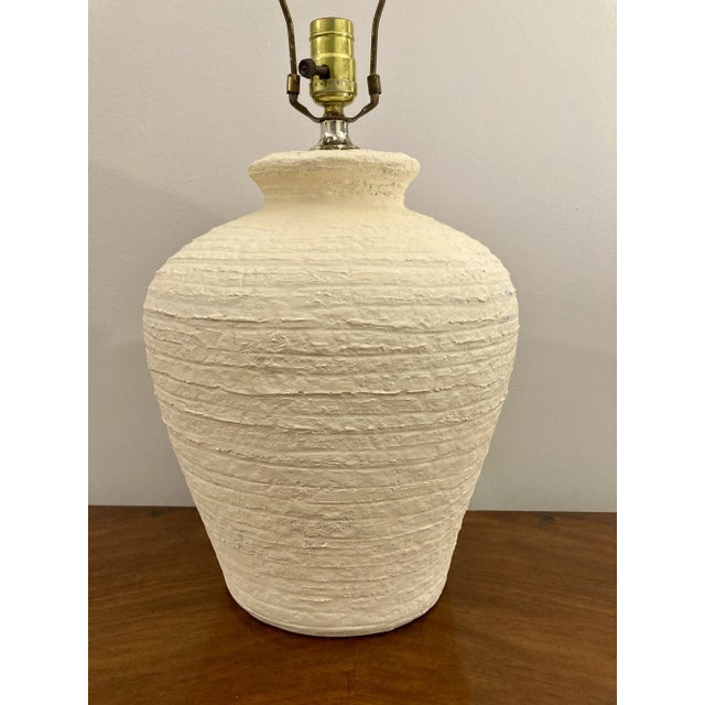 Vintage plaster lamp in a classic urn form and warm cream color. Textured surface pattern with concentric ribs gives the...