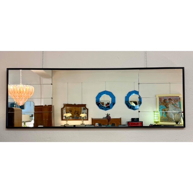 Elegant Italian wall mirror from the 1940s, attributable to Osvaldo Borsani, featuring a refined black lacquered frame and...