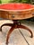 Regency-style mahogany drum table, beautifully highlighted by its striking red gilt-tooled leather inset top with a...