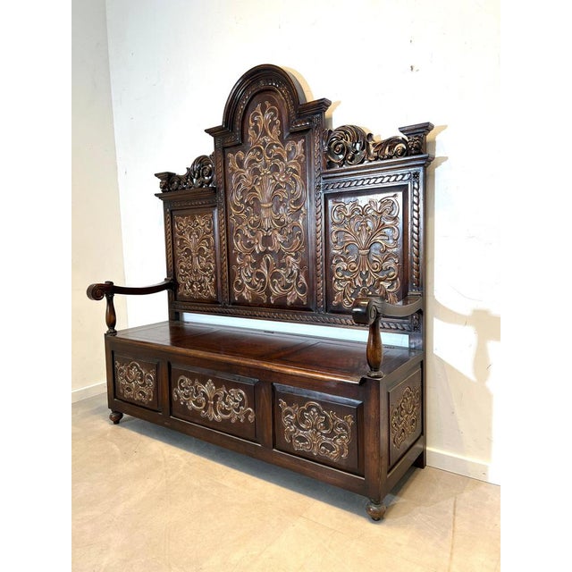 Impressive Victorian hall bench with richly carved decorative panels and integrated storage chest. This striking piece...