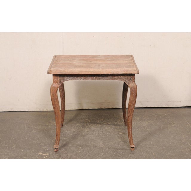A French country square-shaped wooden table from the 18th century. This antique table from France has a square-shaped...