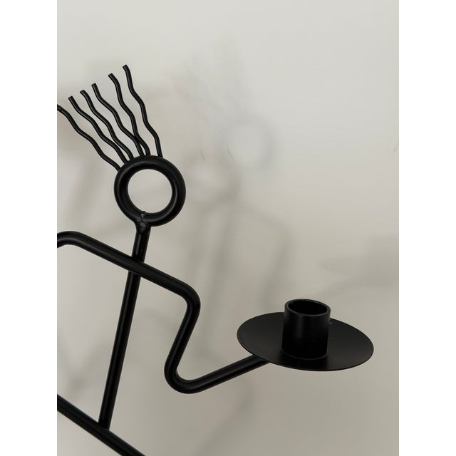 A playful vintage black metal candle holder with strong postmodern presence. Designed as an abstract stick figure in...