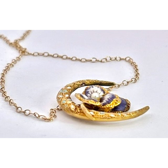 This is a beautiful Art Nouveau-style pendant necklace featuring a crescent moon motif crafted in gold with intricate...