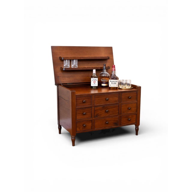 A versatile vintage flip-top bar cabinet featuring a warm, richly toned wood finish and a highly functional interior...