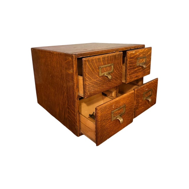 An incredibly rare vintage solid wood desktop library cabinet with four drawers, including all of the original brass...