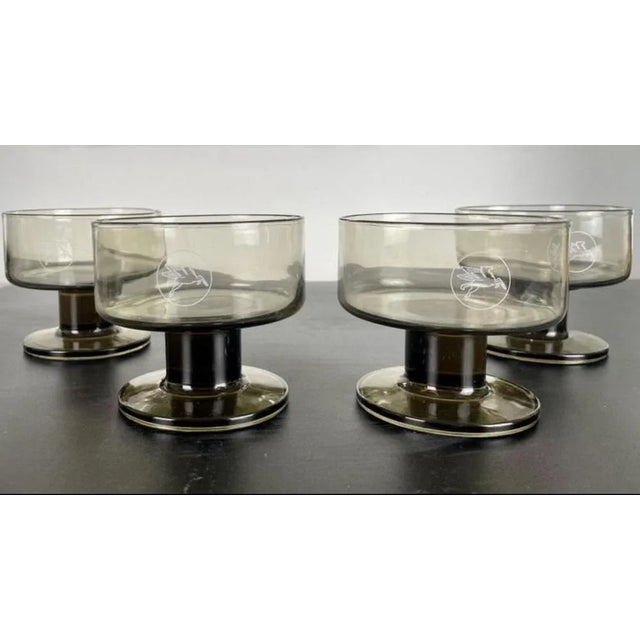 Set of 4 champagne, fruit, ice cream and dessert cups in smoked glass. The Mobil company logo representing Pégase /...
