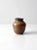 This is a vintage studio pottery vase. Signed by the artist, the hand-crafted vase features a warm brown and gray tone glaze.