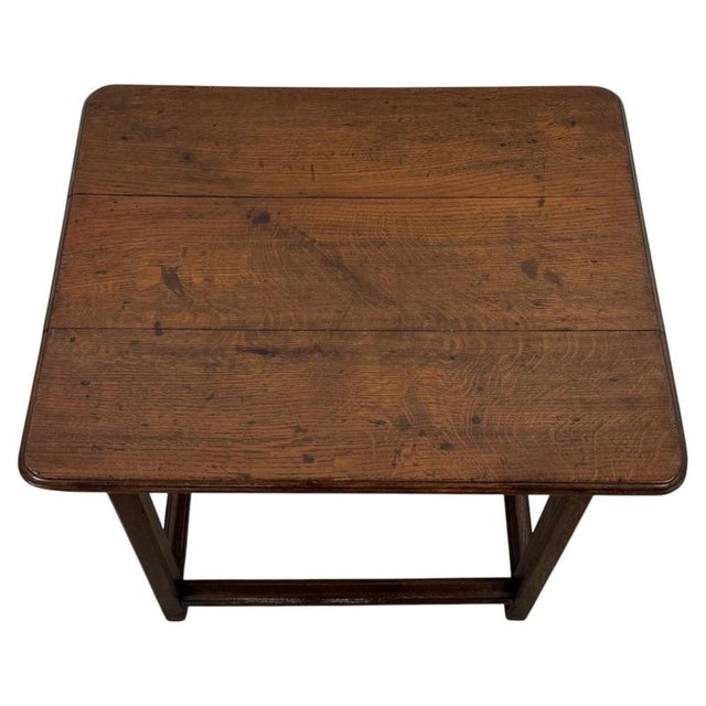 A handsome 19th-century English side table, finely crafted from oak and distinguished by its substantial square legs,...