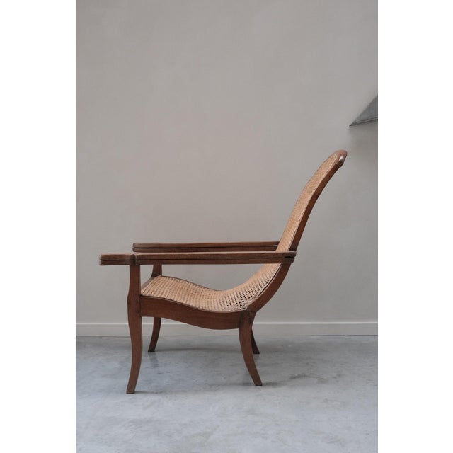 A generously proportioned lounge chair from circa 1870-1900, built around one long, flowing curve. The seat and back form...