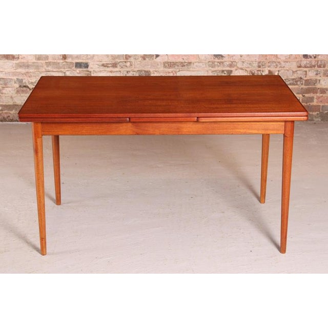 Danish Mid Century extending teak dining table, circa 1970s. 2 extension leaves stored underneath. Excellent restored...