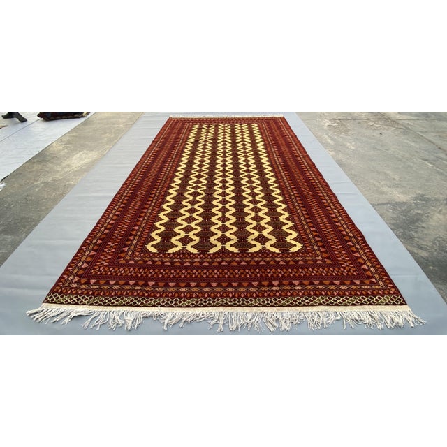 A beautiful hand-knotted Afghan rug featuring the traditional Ersari tribal pattern, highlighted by striking ivory and...