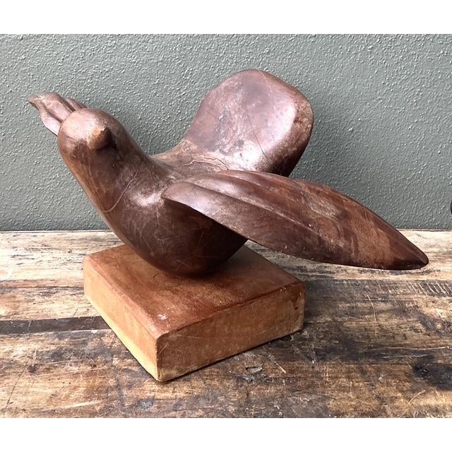 Embrace the graceful, organic lines of the Mid-Century Modern era with this striking hand-carved wood bird sculpture....