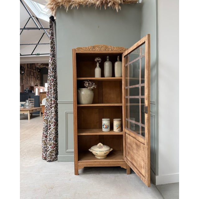 With its sculpted arched pediment, small-paned glass door, and elegantly structured lines, this parisian display cabinet...